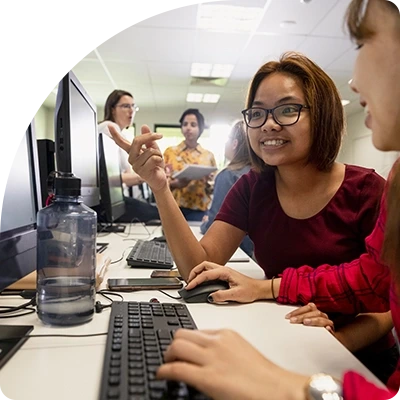 University students work securely on desktop computers in a classroom.